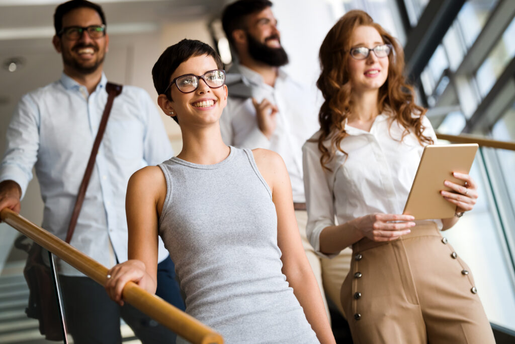 Young corporate professionals happily walking down the stairs of their office.